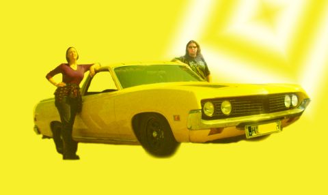 1971 Ford Ranchero - A yellow 1970s coupe utility vehicle is shown from the front 3/4 angle with two women standing next to it.