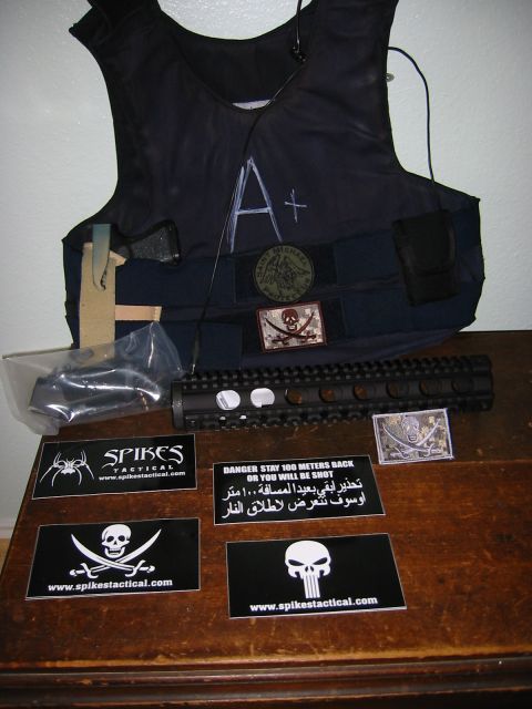 1996 Ford Bronco - A tactical vest adorned with patches and a rifle handguard are displayed on a wooden surface.