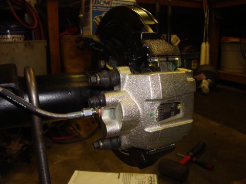 1989 Ford Bronco - Close-up of a rear axle brake caliper, showing brake line connection and part number.