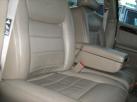 1988 Mercury Grand Marquis - The interior of a car features tan leather seats and a center console armrest with a seatbelt.