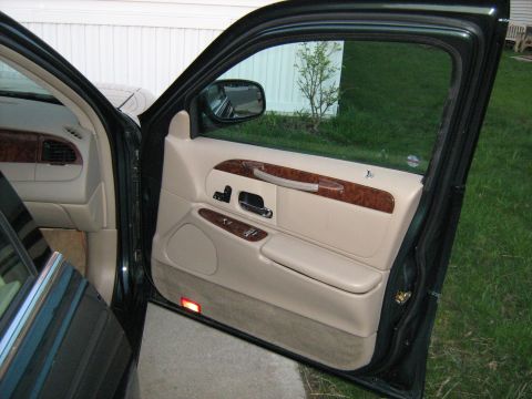 1988 Mercury Grand Marquis - The interior door panel features wood trim accents and beige upholstery, with the door ajar.