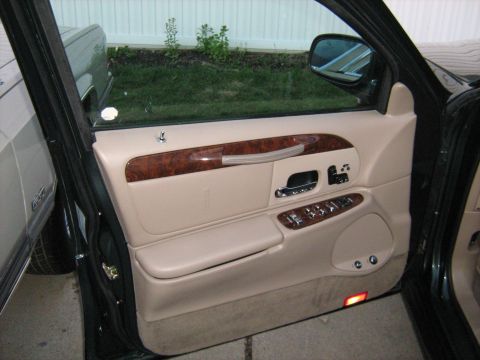 1988 Mercury Grand Marquis - Interior view of a car's door panel showing beige upholstery and wood trim accents.