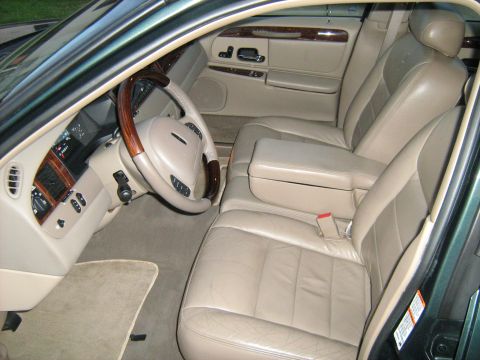 1988 Mercury Grand Marquis - The interior of a car features tan leather seats and wood accents on the dashboard and steering wheel.