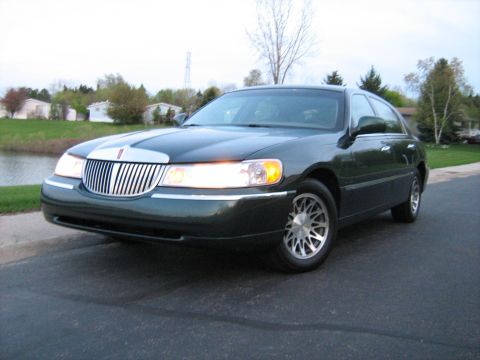 1988 Mercury Grand Marquis - This dark green 2001 Lincoln Town Car is shown from a 3/4 front angle.