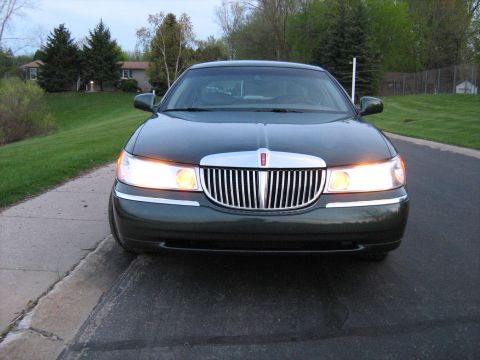 1988 Mercury Grand Marquis - Front view of a dark green Lincoln Town Car parked on a residential street.