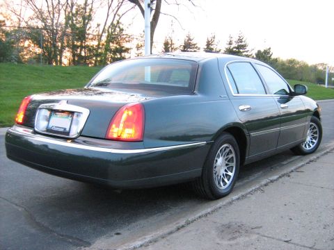 1988 Mercury Grand Marquis - This Lincoln Town Car is seen from its rear quarter, parked on the side of a road.