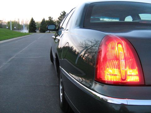 1988 Mercury Grand Marquis - The rear of a dark sedan is shown from a low angle, highlighting its taillight and chrome accents.