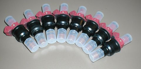 2007 Ford Mustang - A group of eight fuel injectors are arranged in a curve on a neutral surface.