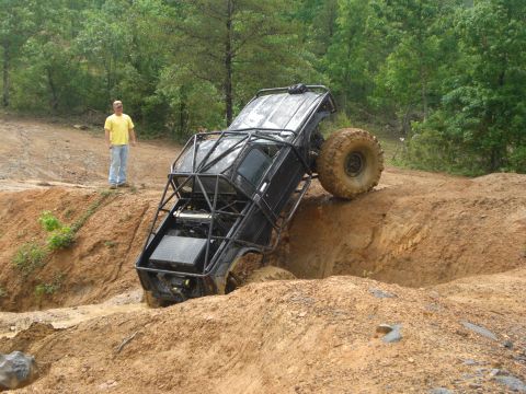 1989 Ford Bronco - A heavily modified off-road vehicle navigates a challenging muddy obstacle course.