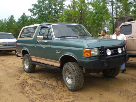 1989 Ford Bronco - This 1989 Ford Bronco is parked outdoors with other vehicles nearby.