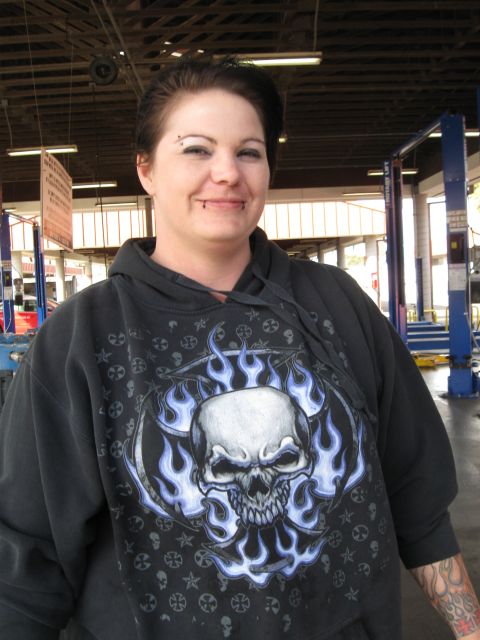 1986 Ford Bronco - A woman with piercings and tattoos poses in a garage setting.