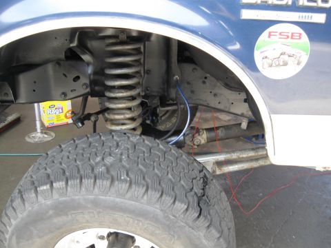1986 Ford Bronco - Close-up of the front suspension and driveshaft on a 1986 Ford Bronco.
