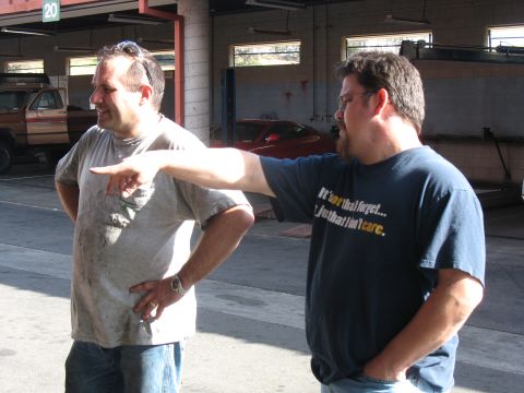 1986 Ford Bronco - Two men stand in a garage, with one gesturing with his finger.