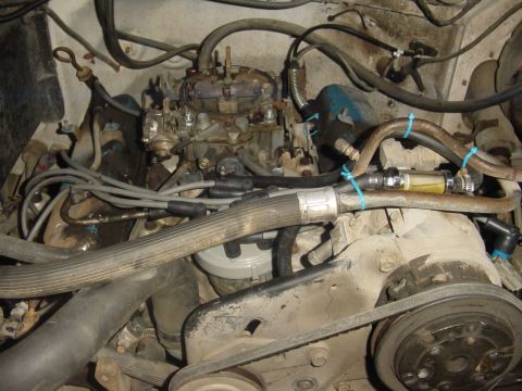 1982 Ford Bronco - Close-up view of an engine bay, highlighting the carburetor and a newly installed fuel filter.