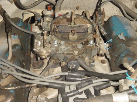 1982 Ford Bronco - Close-up of a vehicle's engine bay, focusing on the carburetor and associated components.