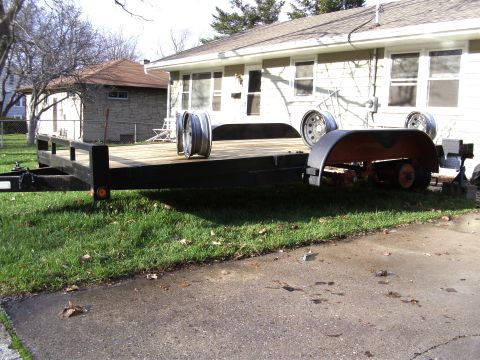 2005 Ford F-250 - A flatbed trailer sits on grass and asphalt in front of a house.