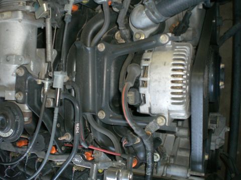 2000 Mercury Grand Marquis - Close-up view of an engine's alternator and surrounding components, with visible hoses and wiring.