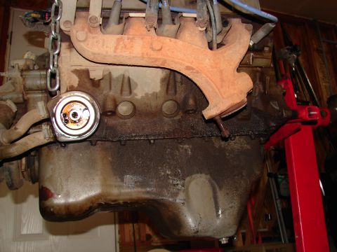 1996 Ford Bronco - Close-up of an engine block, showing the oil filter and exhaust manifold, with a red engine stand in the background.