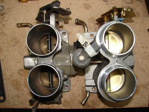 1996 Ford Bronco - Dual throttle body assembly shown on a workbench, likely for engine upgrade or repair.