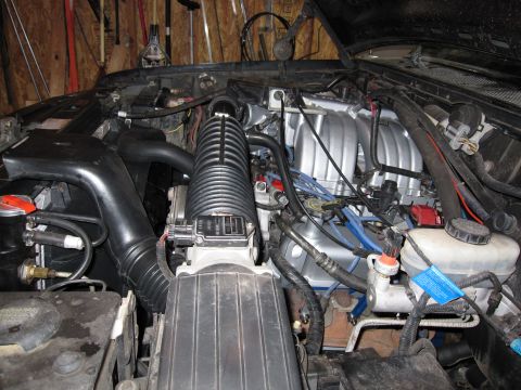 1996 Ford Bronco - Close-up view of an engine bay, a silver intake manifold and a black air intake system.