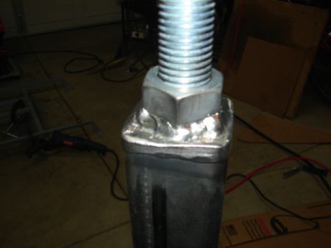 1996 Ford Bronco - A close-up view of the threaded mechanism of a jack stand, showing the adjustment nut and welded components.
