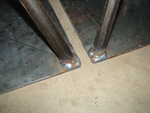 1996 Ford Bronco - Two metal components are joined by welding, showing the connection points of cylindrical supports to flat plates.