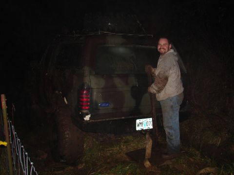 1996 Ford Bronco - A man stands by a muddy 1996 Ford Bronco, which has been painted with camouflage.