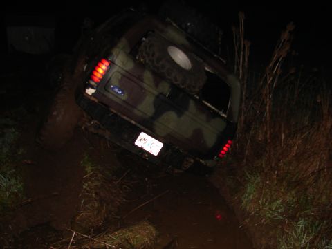 1996 Ford Bronco - This 1996 Ford Bronco is stuck in the mud, its rear end visible in the dark.