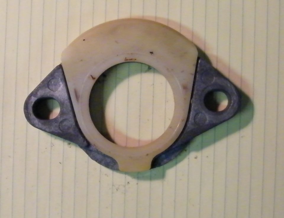 Tan phenolic insulator ring assembled on two-bolt cast spacer flange, lined paper