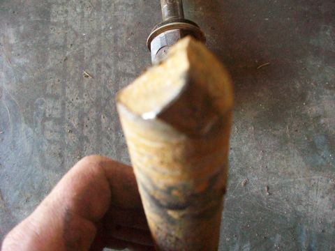 1992 Ford F-350 - A metal rod with a hexagonal nut is shown, with a hand holding it.