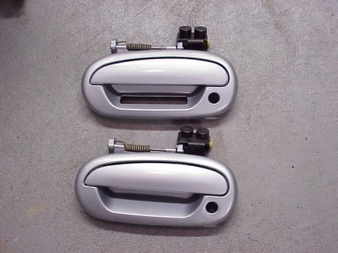 2007 Ford Mustang - A pair of silver car door handles are shown against a textured gray background.