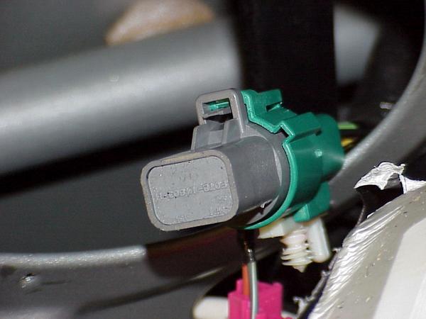Close-up of a gray and green electrical connector with some text on it