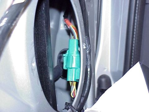 2007 Ford Mustang - A green wiring harness connector is visible within the gray interior of a vehicle, showing its internal wiring.