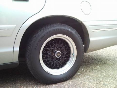 1998 Ford Crown Victoria - Rear quarter view of a 1998 Ford Crown Victoria, its distinctive black wire-spoke wheels.