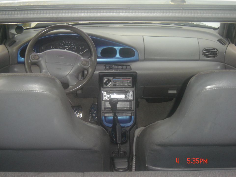 Interior shot of a car, showing the dashboard, steering wheel, center console with gear shifter, and front seats
