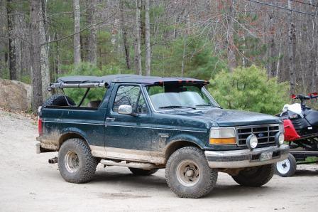 1993 Ford Bronco - This 1993 Ford Bronco is seen in a wooded area with a snowmobile on a trailer behind it.