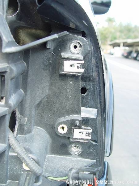 2007 Ford Mustang - Close-up view of a vehicle's taillight housing, showing mounting hardware and electrical connections.