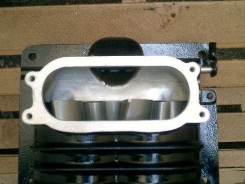 2007 Ford Mustang - Intake manifold part shown with gasket. The ribbed black body contrasts with the silver interior.