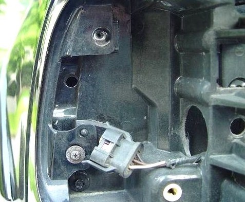 2007 Ford Mustang - Interior view of a vehicle's taillight assembly, highlighting the mounting bracket and wiring harness connector.