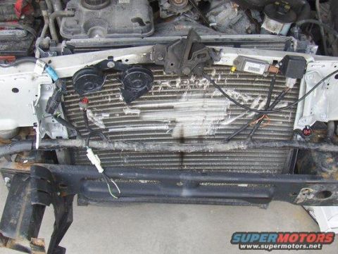 2003 Ford Crown Victoria - Front view of a damaged 2003 Ford Crown Victoria engine bay, showing a compromised radiator and various electrical components.