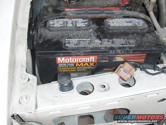Motorcraft car battery in engine bay. Shows danger/poison warnings and 36-month/100-month service life