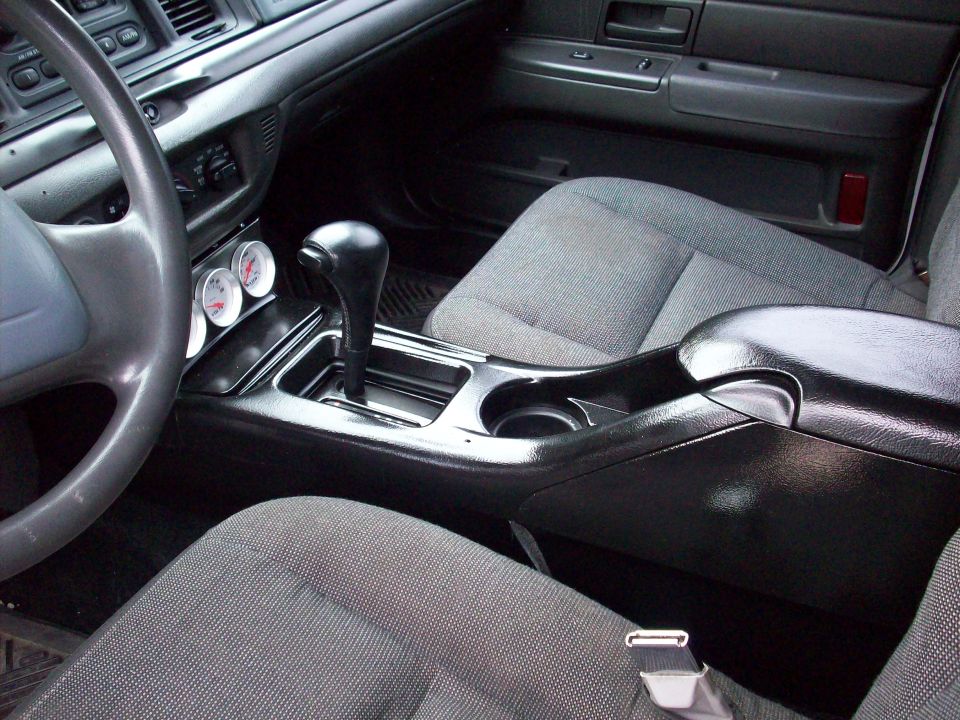 Crown Victoria interior center console with floor shifter, cup holders and gray cloth bucket seats