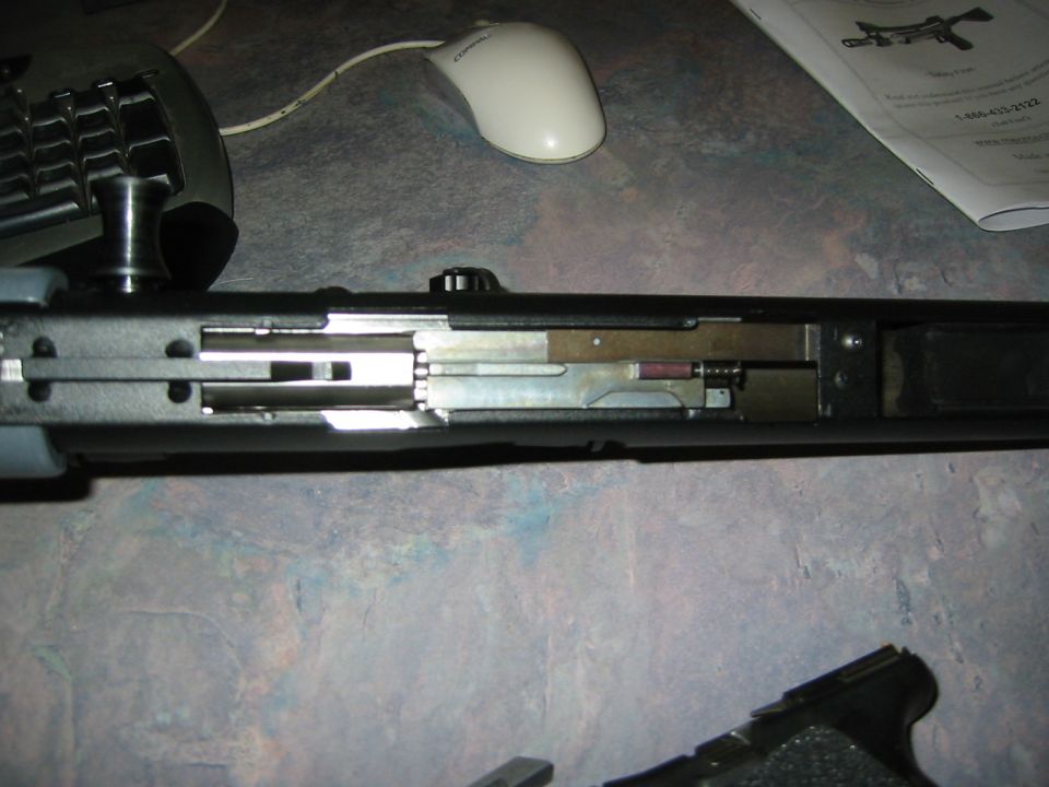 Close-up of a disassembled mechanical assembly with visible metal components and a small red cylinder