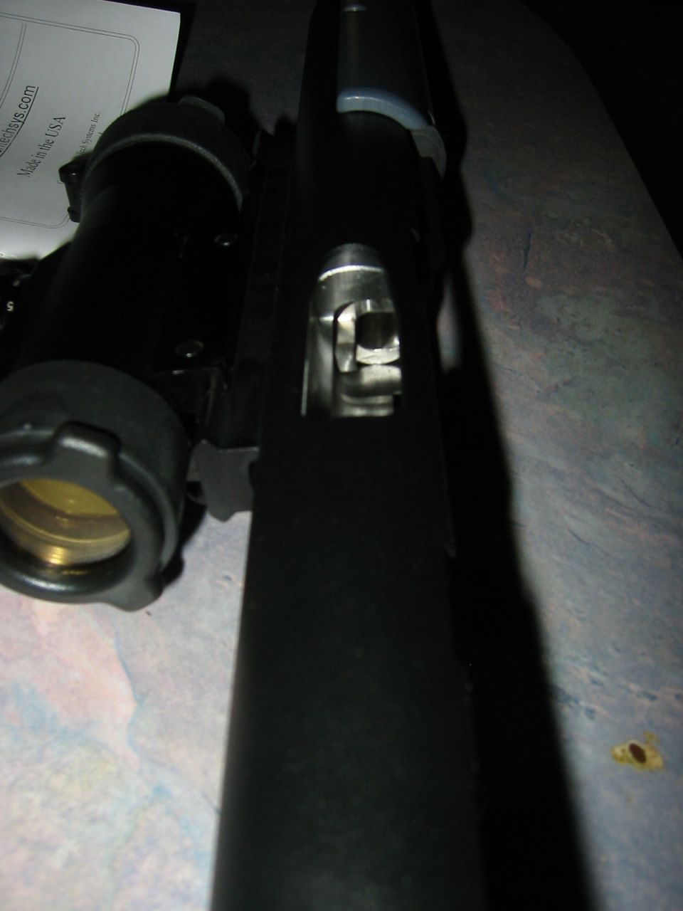 close-up of firearm slide and barrel assembly, with a scope mount to the left