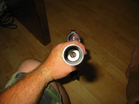 1996 Ford Bronco - A hand holds a metal tube, revealing an internal spring mechanism against a wooden floor background.