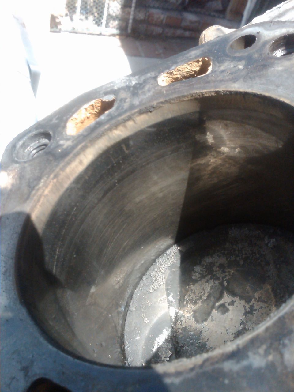 Close-up of a corroded engine cylinder block with visible rust and wear inside the bore