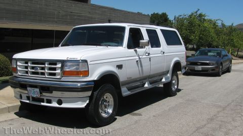 1996 Ford C-350 (Centurion Conversions) - White 1996 Ford C-350 (Centurion Conversions) and a gray Ford Mustang parked on a street.