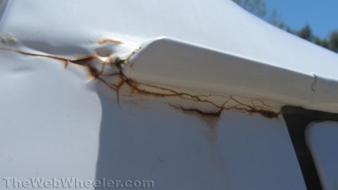 1996 Ford C-350 (Centurion Conversions) - Rust and cracked paint are visible on the body of a white vehicle, indicating wear and tear.