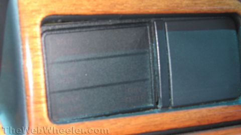 1996 Ford C-350 (Centurion Conversions) - Close-up of an unlit dashboard warning-light cluster set into a woodgrain dash trim panel, with the indicator legends only faintly readable…