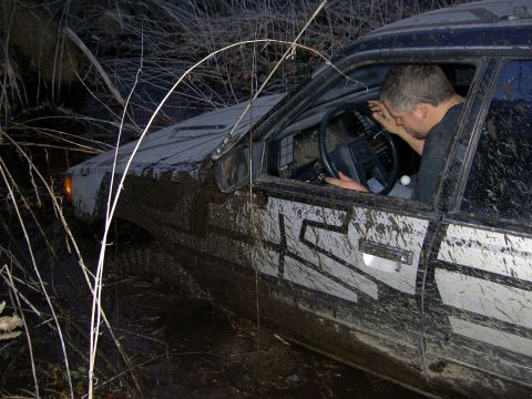 1992 Ford Bronco - This vehicle appears to be stuck deep in the mud, with the driver looking exhausted.